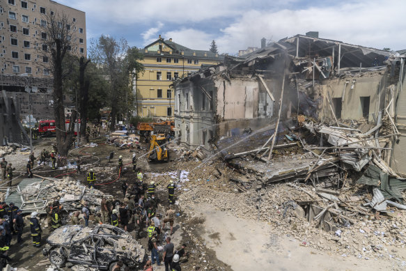 Firefighters hose down the flattened corner of a building after a Russian missile strike on the Okhmadyt children’s hospital in Kyiv.