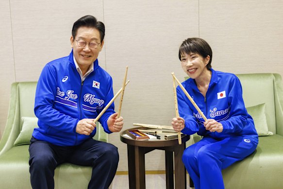 Il primo ministro giapponese Sanae Takaichi (a destra) e il presidente sudcoreano Lee Jae Myung (a sinistra) posano per una foto durante la loro sessione musicale.