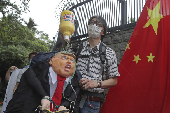 Pro-China supporters hold the effigy of US President Donald Trump and a Chinese national flag outside the US Consulate during a protest in Hong Kong on Saturday.