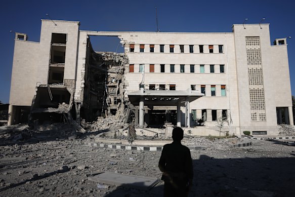 A person passes by the site of an Israeli airstrike on Syria’s defence ministry headquarters in Damascus, Syria. 