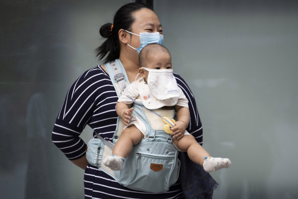 A woman and baby wear masks to help protect against the coronavirus in Beijing.