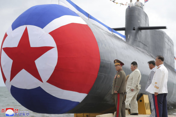 North Korea leader Kim Jong-un, second left, looks at what is says a new nuclear attack submarine “Hero Kim Kun Ok” at an unspecified location on Wednesday.