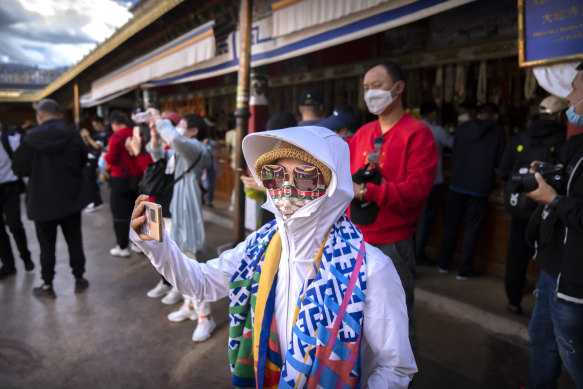 A tourist takes a photo at the Jokhang Temple in Lhasa in western China’s Tibet Autonomous Region, where tourism is booming.