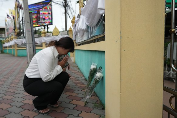 Una donna depone fiori e offre preghiere alla scuola Debsirin Nonthaburi il sabato.