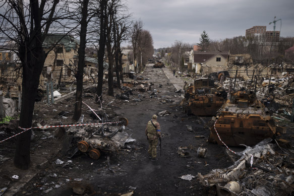 A Ukrainian serviceman walks amid destroyed Russian tanks in Bucha, on the outskirts of Kyiv, Ukraine.