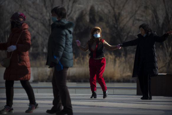 People wearing face masks to curb the spread of the coronavirus dance at a public park in Beijing, as parts of the neighbouring Hebei province have been classified a coronavirus high danger zone.