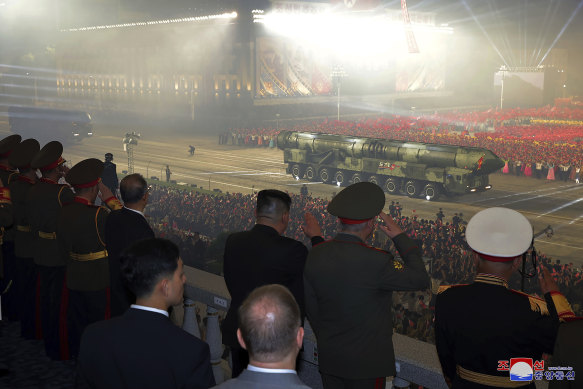 North Korean leader Kim Jong-un (centre) watches a Hwasong-18 intercontinental ballistic missile during the parade.