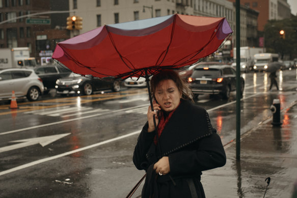 A woman holds her umbrella as she speaks on the phone on Friday in Brooklyn.