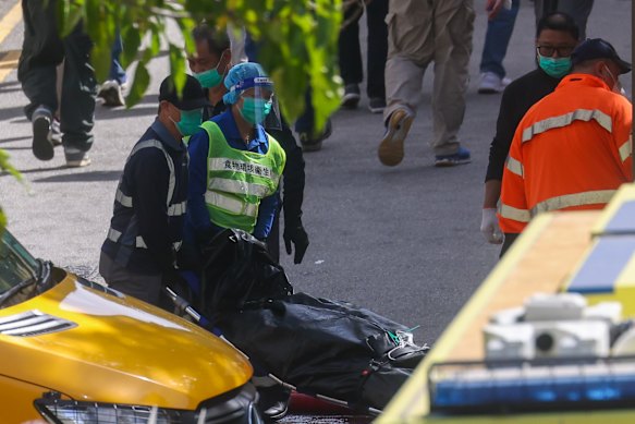 Search and rescue workers move bodies onto a truck.