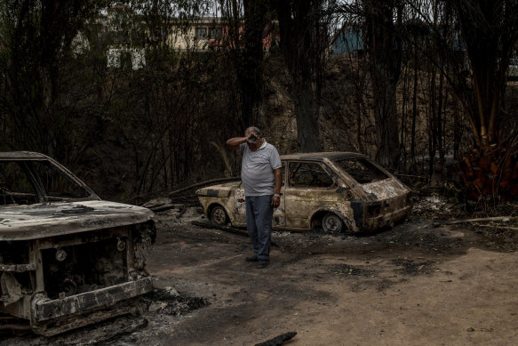 Omar Castro walks around the remains of his house.