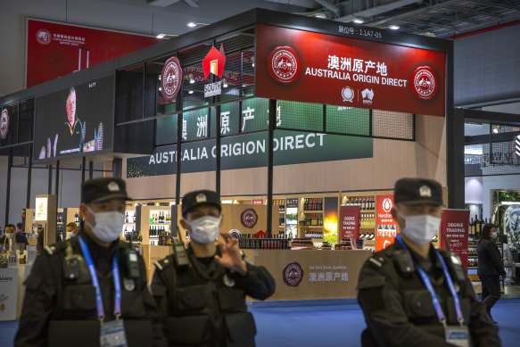 Security officers walk past a display of Australian wines and other agricultural products at the China International Import Expo in Shanghai.