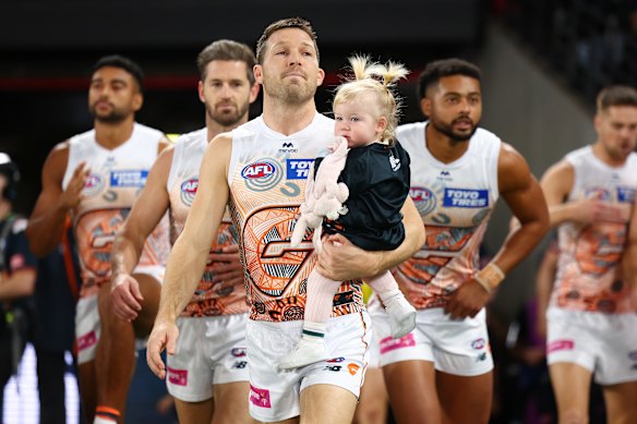 Toby Greene prepares to take his daughter through his milestone banner.