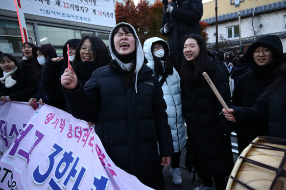 South Korean high-school students cheer for their senior classmates, among the half a million taking the rigorous College Scholastic Ability Test in Seoul 2019.