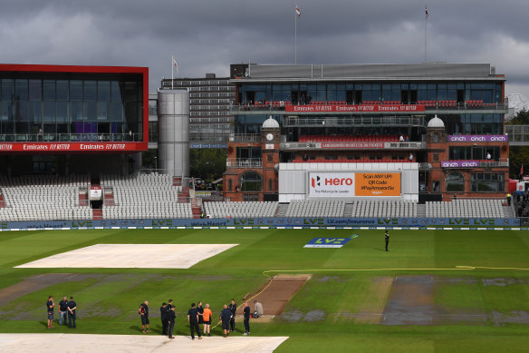 Old Trafford staff gather on the field after the cancellation of the fifth Test between England and India.