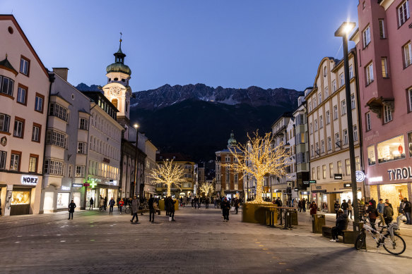 People walk through a shopping street already illuminated for Christmas on  in Innsbruck, Austria. From Monday the Christmas markets will open but only for people who have either recovered from or been vaccinated against COVID-19.