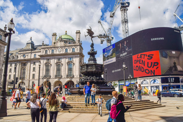 Tourists return to London’s Piccadilly Circus following the relaxation of coronavirus restrictions and quarantine rules in England over the past few weeks.