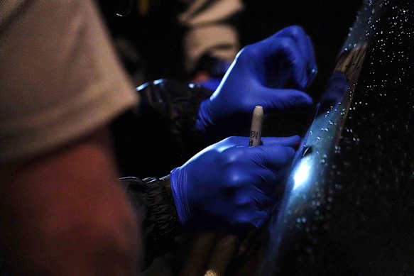 Investigators work on the Range Rover before it is removed.