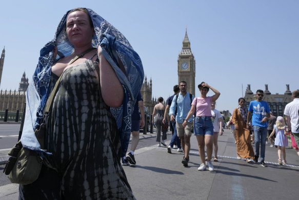 Pedestrians shelter from the sun on London’s Westminster Bridge this week.