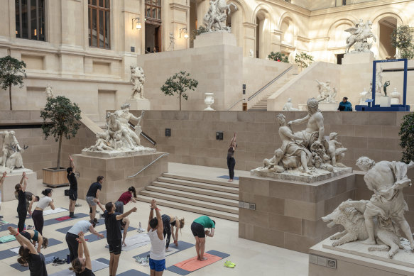 A yoga class, held before crowds arrive, in the Louvre Museum in Paris.