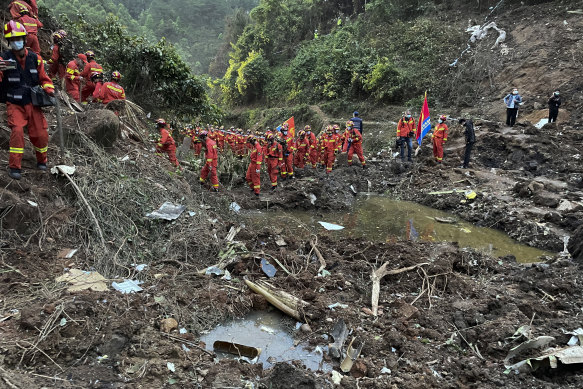 Rescuers work at the site of the plane crash in Tengxian County in southern China before rains topped the search.
