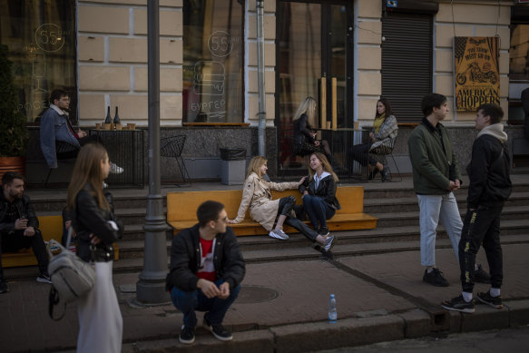 People gather and talk outside a terrace bar in central Kyiv.