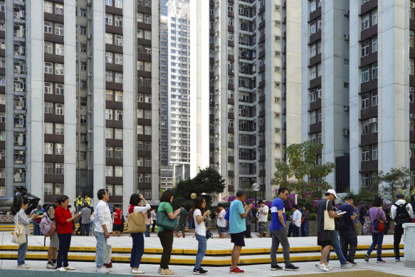 Voters line up outside a polling place in Hong Kong on Sunday.