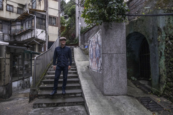 Wang Chieh near the walls outside a Keelung bunker that he decorated with a mural .