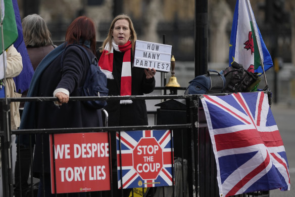 An anti-Boris Johnson demonstrator holds a placard in February questioning how many lockdown-breaching parties were held in the office of the British prime minister during the pandemic.