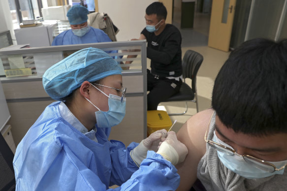 An airport worker in China’s Jiangsu province gets a Sinovac vaccine. 