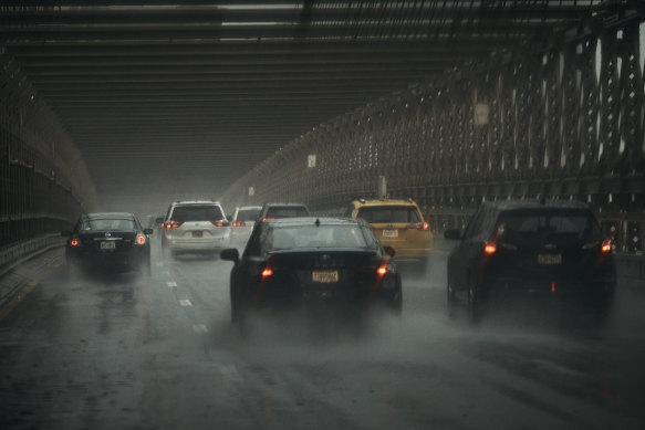 Cars move along Brooklyn Bridge under heavy rain on Friday.