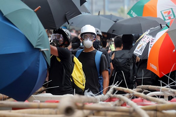 A protester stands at a barricade made of bamboo poles in Hong Kong on Saturday. Pro-democracy protesters took to the streets calling for the removal of lamp posts that raised fears of increased surveillance.