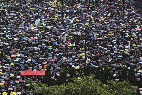 Protesters carrying umbrellas gather on Sunday.