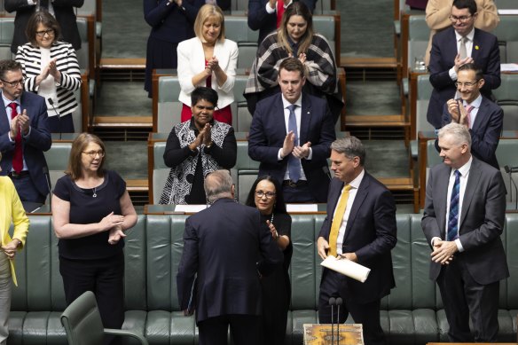 The PM is applauded by colleagues after speaking in the House of Representatives this morning. 