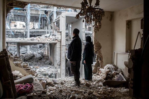 A couple stands in the ruins of their Tehran apartment.