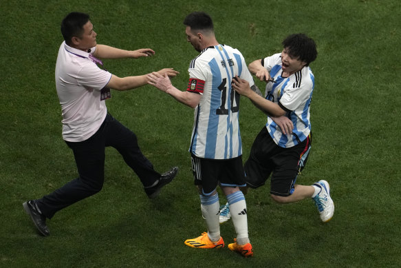 A steward pursuing a Chinese fan who invaded the pitch.