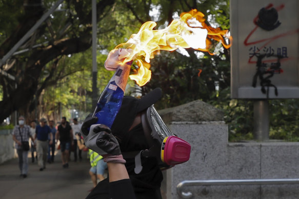 A protester prepares to throw a molotov cocktail at the Tsim She Tsui police station during Sunday's protests.