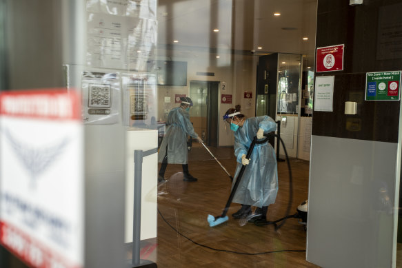 Cleaners wearing protective equipment disinfect the Holiday Inn quarantine hotel at Melbourne Airport.