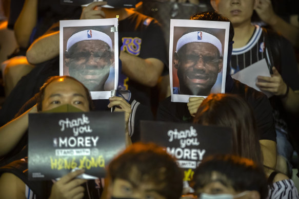 Demonstrators hold up photos of LeBron James grimacing during a rally in Hong Kong.