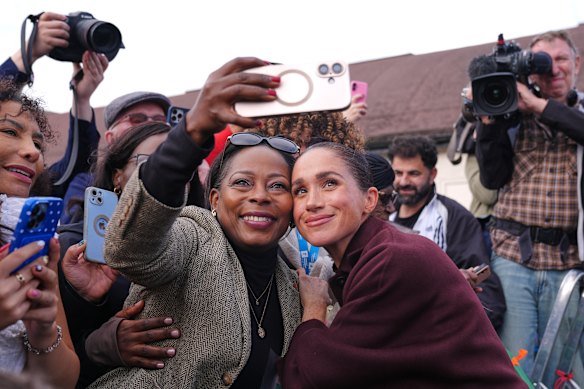 Meghan poses for a selfie with a member of the public.