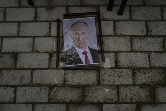 A smashed portrait of Russian President Vladimir Putin lies outside a police prison used to hold and torture Ukrainian prisoners by Russian forces in Kherson, Ukraine on November 17, 2022.