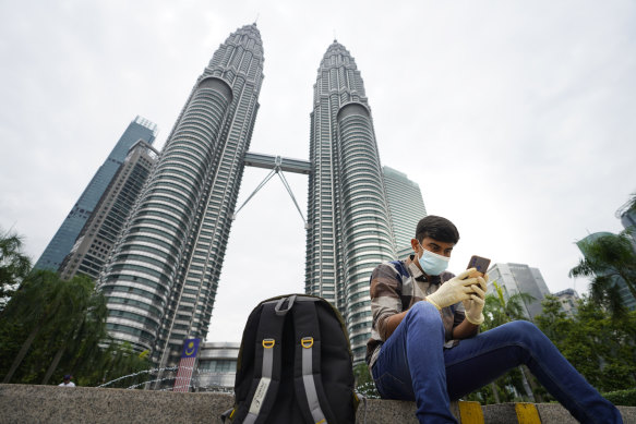 A man looks at his mobile phone in front of Twin Towers in Kuala Lumpur, Malaysia. Huawei is tipped as the frontrunner to build the country’s 5G network.