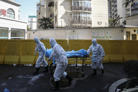 Medical workers move a person who died from COVID-19 at a hospital in Wuhan in Febuary 2020, at the beginning of the pandemic.