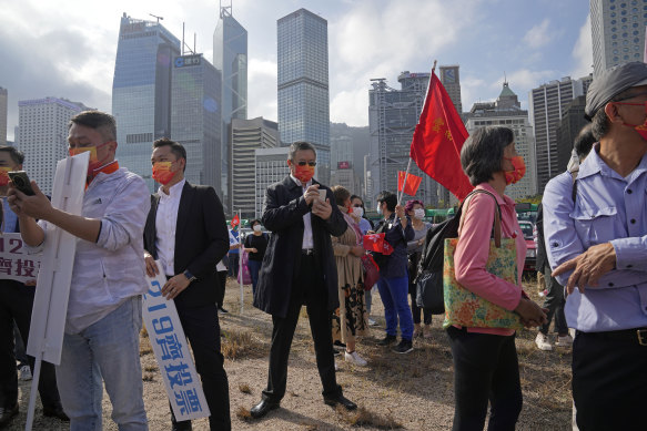 Pro-Beijing supporters hold flags and placards ahead of elections in Hong Kong in December. 