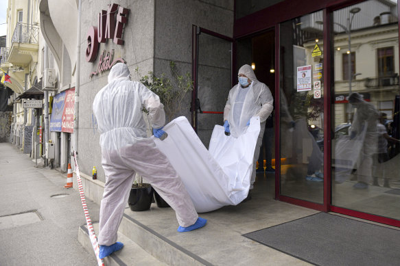 Forensic workers carry the body of Gholamreza Mansouri from a hotel in  Bucharest, Romania