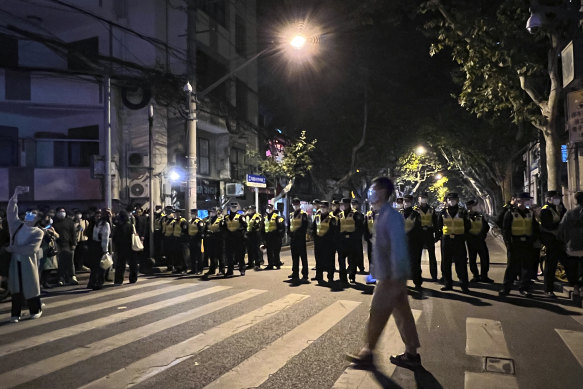 Chinese police officers block off access to a site where protesters had gathered in Shanghai on Sunday.