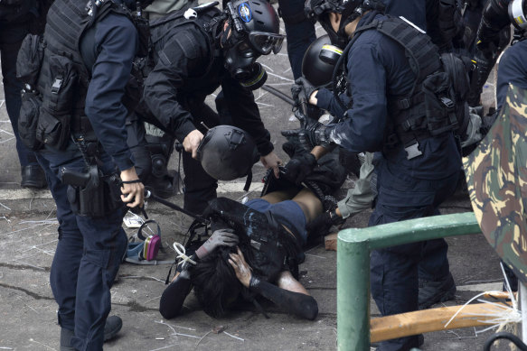 Policemen in riot gear detain a protester who was trying to flee from the Hong Kong Polytechnic University.