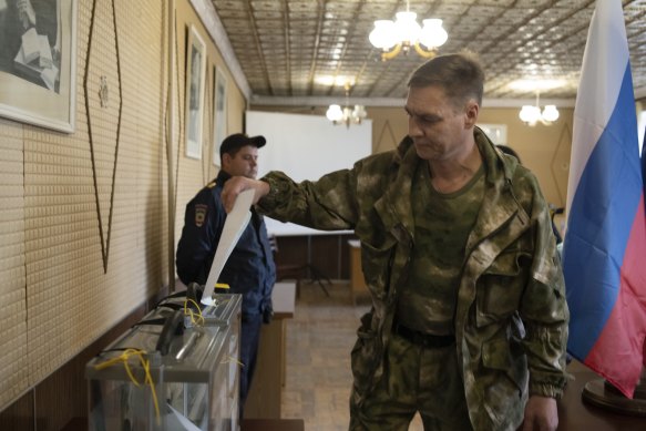 Bir Luhansk Halk Cumhuriyeti askeri, Luhansk'taki bir sandıkta oy kullanıyor.