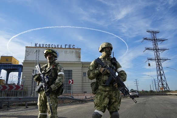 Russian troops guard an entrance of the Kakhovka Hydroelectric Station, a run-of-river power plant on the Dnieper River in Kherson region, south Ukraine.
