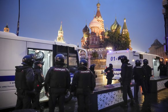 Police officers stand near police buses with detained demonstrators during a protest against a partial mobilisation near Moscow’s Red Square.