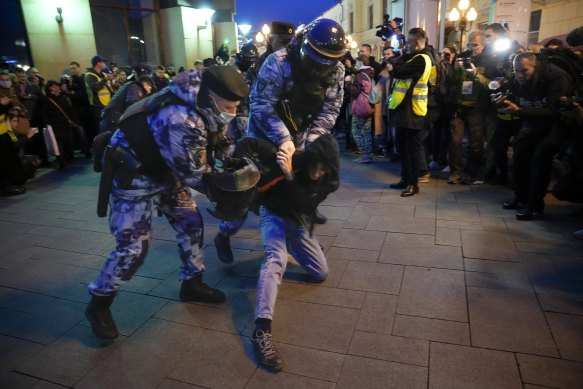 Çevik kuvvet polisi Moskova'da seferberliğe karşı düzenlenen protesto sırasında bir göstericiyi gözaltına aldı.